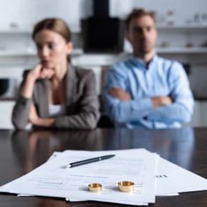 Man and woman at table with papers and a wedding rings - Yarbrough Law Firm.