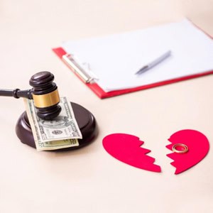 A judge's gavel next to a broken heart and money on a desk representing Alabama’s Divorce Process, - Yarbrough Law Firm