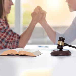 A man and woman arm wrestling, representing a contested divorce in Alabama - Yarbrough Law Firm